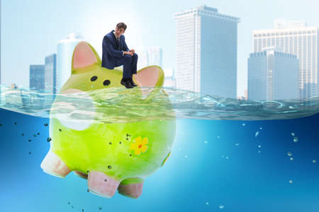 Businessman in debt concept with the piggybankの写真素材
