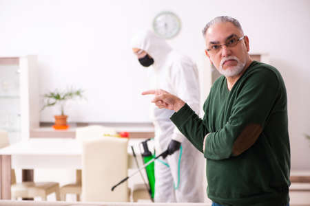 Young male sanitizer and old man indoorsの写真素材