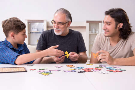 Three generations of family playing jigsaw puzzle game