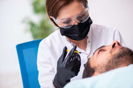 Young man visiting beautician in hair transplantation conceptの写真素材