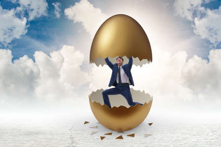Businessman breaking out of golden eggの写真素材