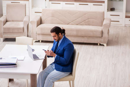 Young male employee working from house in self-isolation conceptの写真素材