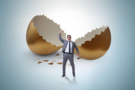 Businessman breaking out of golden egg