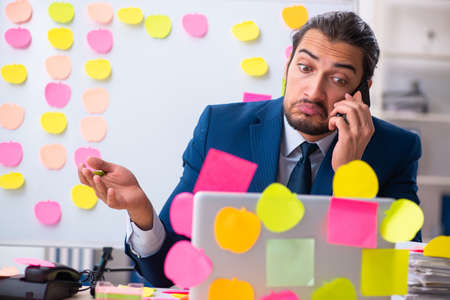 Young male employee in conflicting priorities conceptの写真素材