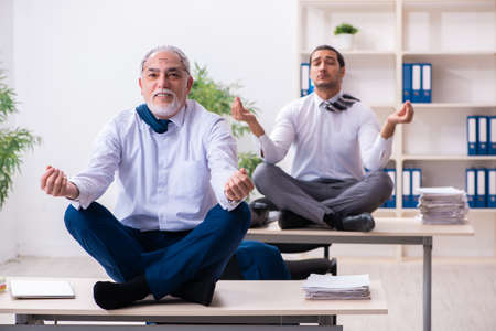 Two male employees working in the officeの写真素材