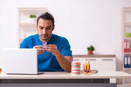 Young male dentist working in the clinicの写真素材