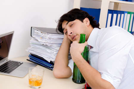 Young businessman employee drinking in the office