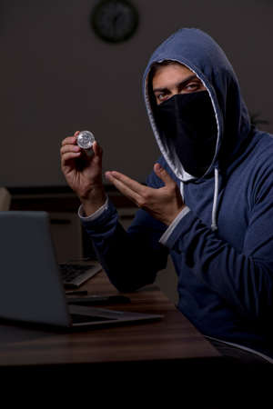 Male hacker hacking security firewall late in officeの写真素材