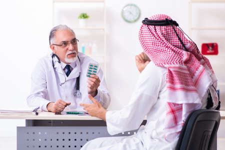 Young male arab visiting experienced male doctorの写真素材