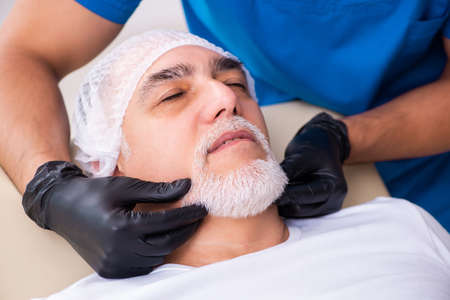 Old man visiting male doctor for plastic surgeryの写真素材