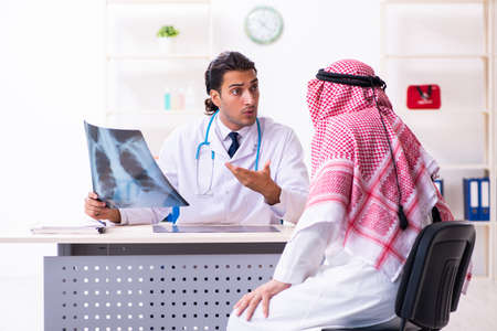 Old male arab visiting young male doctorの写真素材