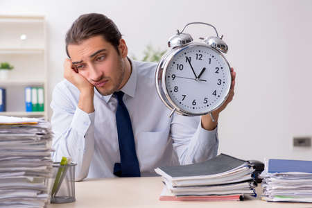 Young male businessman employee unhappy with excessive workの写真素材