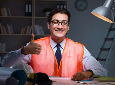 Construction architect working on drawings late at nightの写真素材