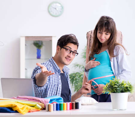 Pregnant woman visiting tailor for new clothingの写真素材