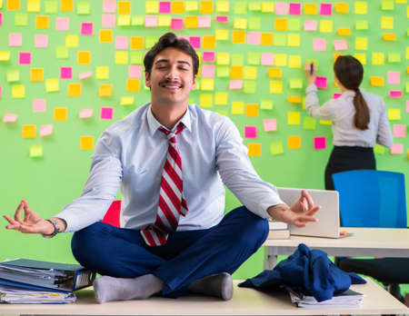 Man and woman in the office with many conflicting priorities inの写真素材