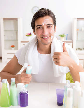 Young handsome man in the bathroom in hygiene conceptの写真素材