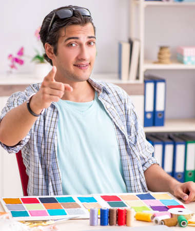 Young handsome tailor working in his workshopの写真素材