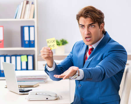 Office prank with kick me message on sticky noteの写真素材