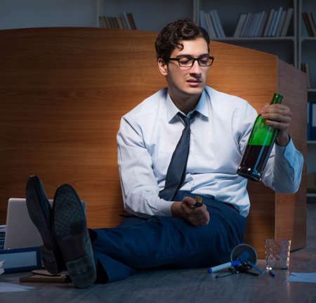 Stressed businessman working overtime in depressionの写真素材