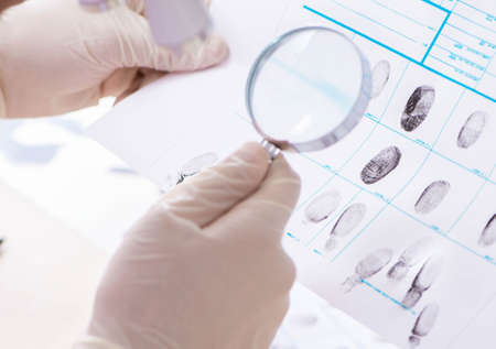Forensic expert studying fingerprints in the labの写真素材