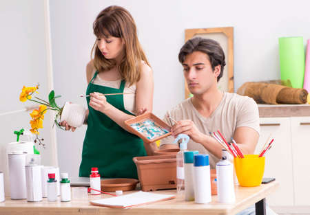 Couple decorating pots in workshop during classの写真素材