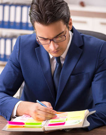 Young handsome employee planning his work activityの写真素材