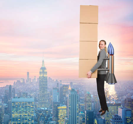 Woman in fast box delivery service on rocketの写真素材