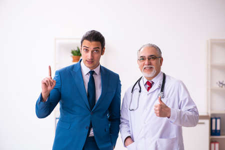 Young businessman meeting with old doctorの写真素材