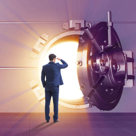 Businessman in front of banking vault doorの写真素材