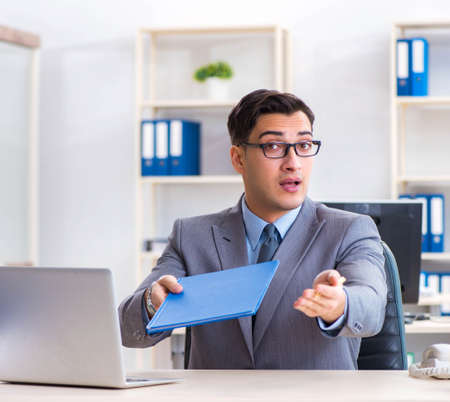 Handsome businessman employee sitting at his desk in officeの写真素材