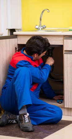 Plumber repairing wash basin at kitchenの写真素材