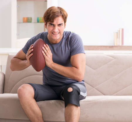 Injured man recovering at home from sports injuryの写真素材
