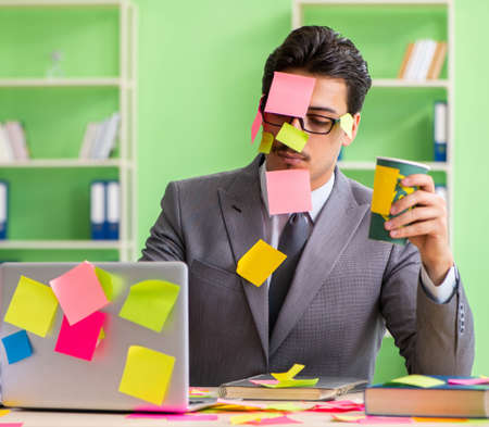 Businessman unhappy with many conflicting priorities sitting inの写真素材
