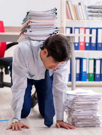 Extremely busy employee working in the officeの写真素材