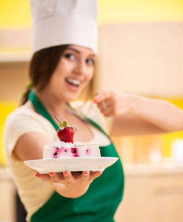 Young cook cooking cakes in the kitchenの写真素材