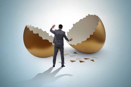Businessman breaking out of golden egg