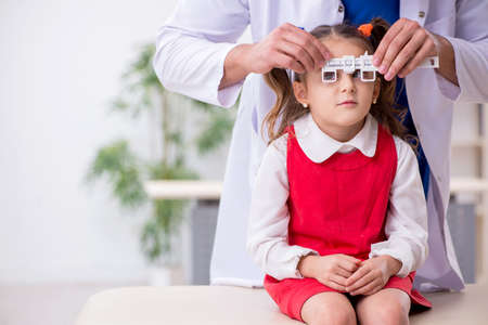 Small girl visiting young male doctor oculistの写真素材