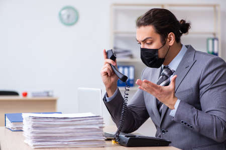 Young male employee in self-quarantine conceptの写真素材