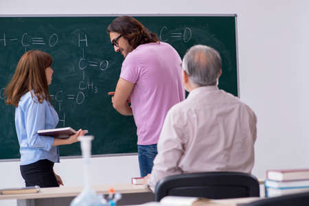 Old teacher and two students in the classroomの写真素材