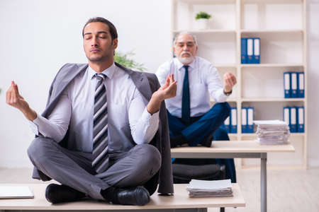 Two male employees working in the officeの写真素材