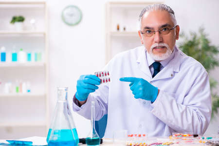 Old male chemist working in the lab
