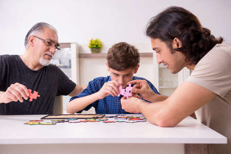 Three generations of family playing jigsaw puzzle game