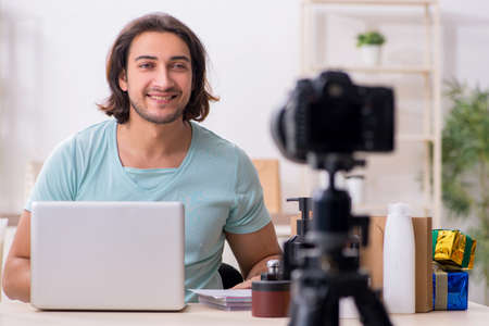 Young male shopaholic recording video for his blogの写真素材