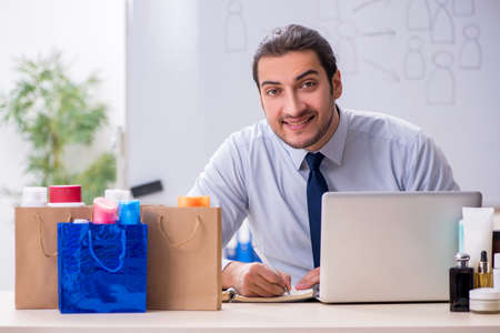 Young male shopaholic in e-commerce conceptの写真素材