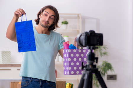 Young male shopaholic recording video for his blogの写真素材