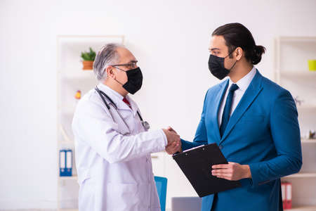 Young businessman meeting with old doctor