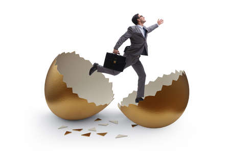 Businessman breaking out of golden egg