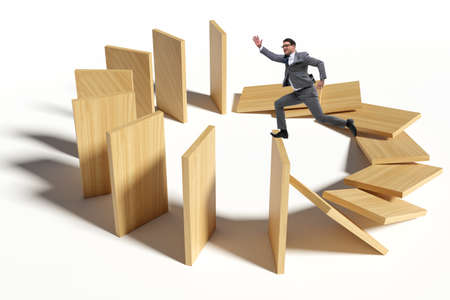 Businessman in domino effect conceptの写真素材