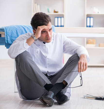 Doctor sitting on the floor in hospitalの写真素材