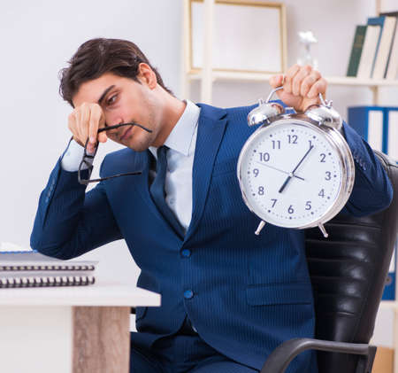Businessman employee in urgency and deadline concept with alarmの写真素材